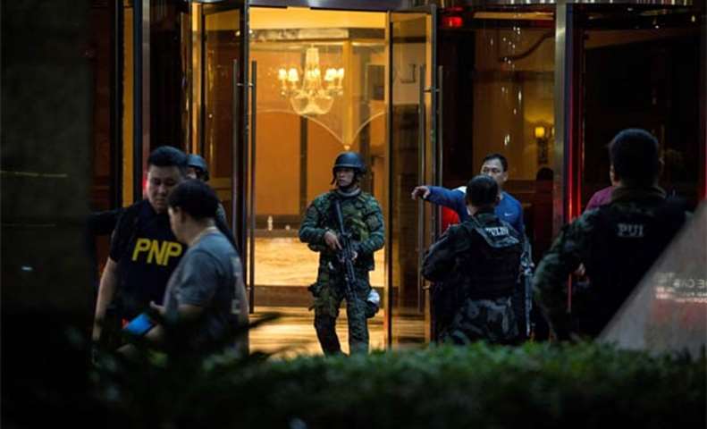 Police officers come out of the Resorts World Hotel in Manila following an assault