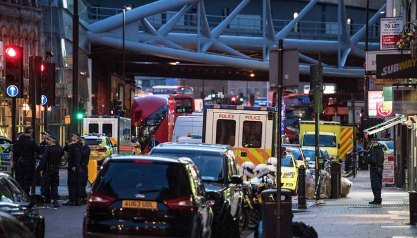Police officers and emergency response vehicles are seen on the street outside Borough Market