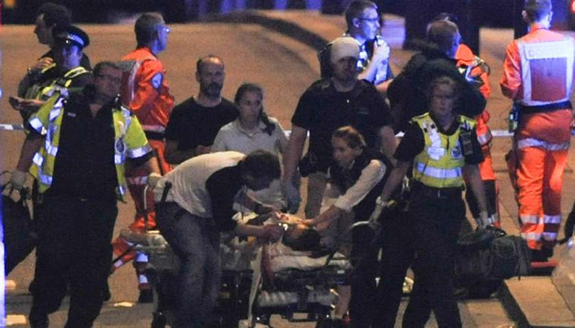 Police and members of the emergency services attend to victims of a terror attack on London Bridge