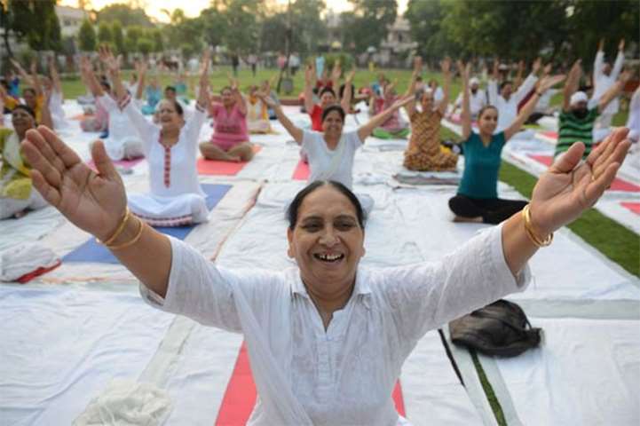 Indian yoga practitioners raise their arms during a session in Amritsar