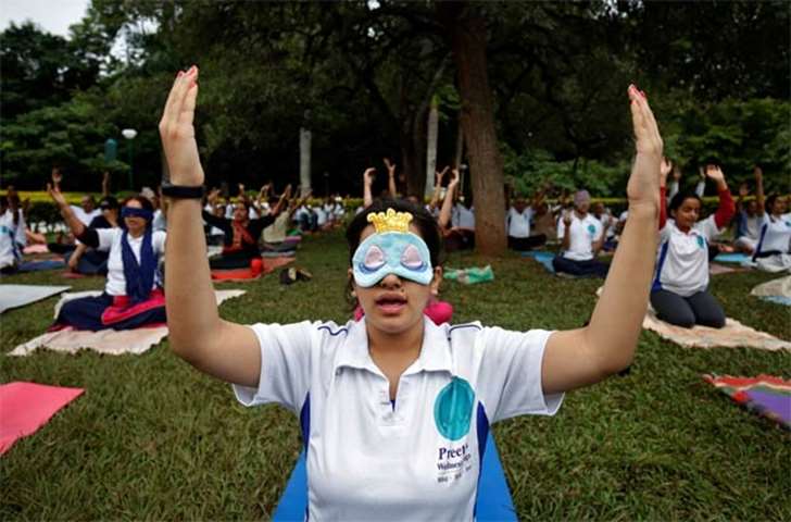 A girl wears a blindfold as she attends a yoga session at a park in Bengaluru on Wednesday