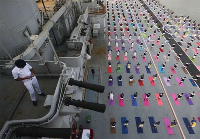 Members of the Indian Navy perform yoga on the flight deck of INS Viraat, a decommissioned carrier