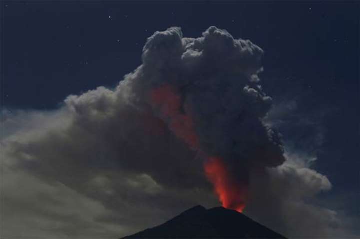 Mount Agung volcano erupts during the night, as seen from Datah village in Bali