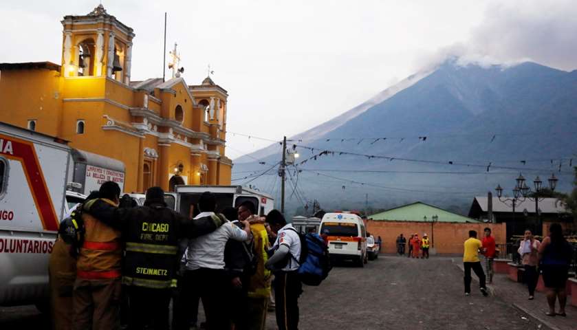 Firefighters pray after Fuego volcano erupted violently