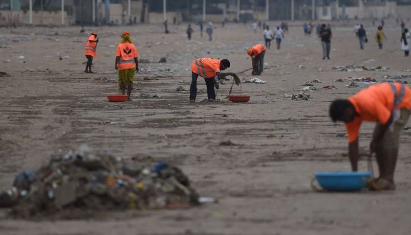 Municipal authority workers clean up plastic waste - Juhu beach, Mumbai, India