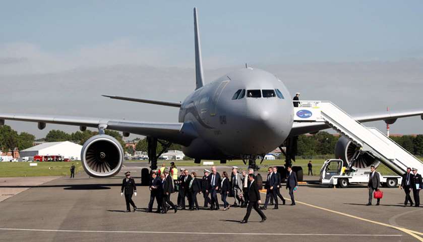 French President Emmanuel Macron (2ndL) walks past an Airbus A330 MRTT as he arrives with officials