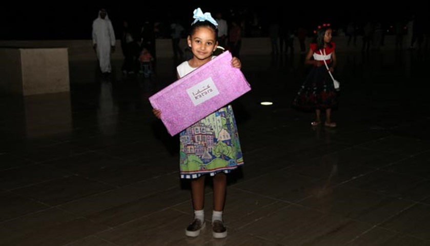 A girl poses with a prize she received during the festivities at Katara