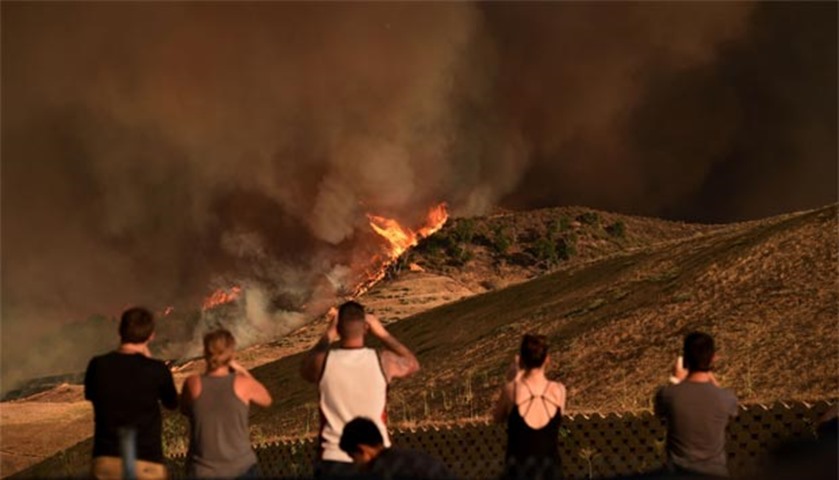 Local residents watch a blaze as the Sand Fire moves towards Fair Oaks Canyon housing estate