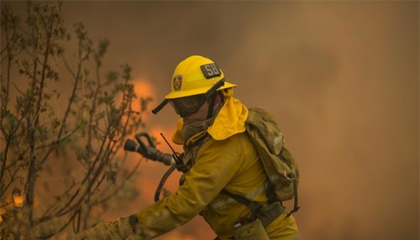 A firefighter steps away from flames in Placerita Canyon at the Sand Fire in Santa Clarita