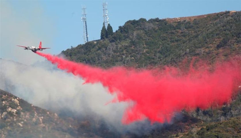 A firefighting aircraft drops fire retardant on the Sand Fire in the Angeles National Forest