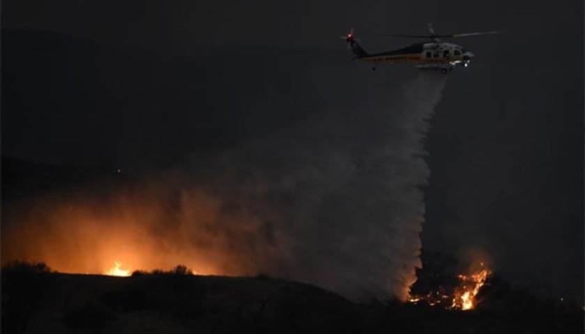 A firefighting helicopter drops water at Fair Oaks Canyon during the Sand Fire in Santa Clarita