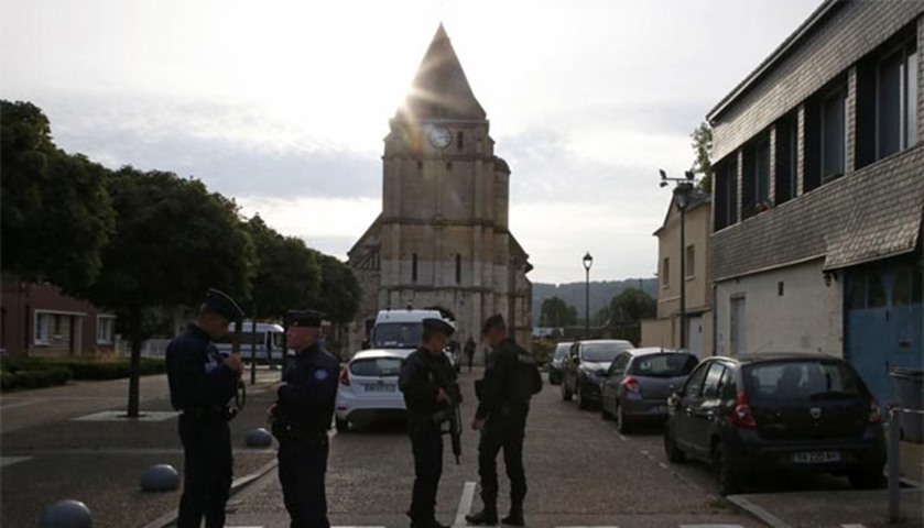 French CRS police stand guard in front of the church a day after a French priest was killed