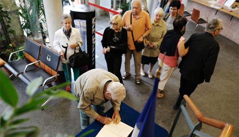 People sign a book inside the city hall in Saint-Etienne-du-Rouvray on Wednesday