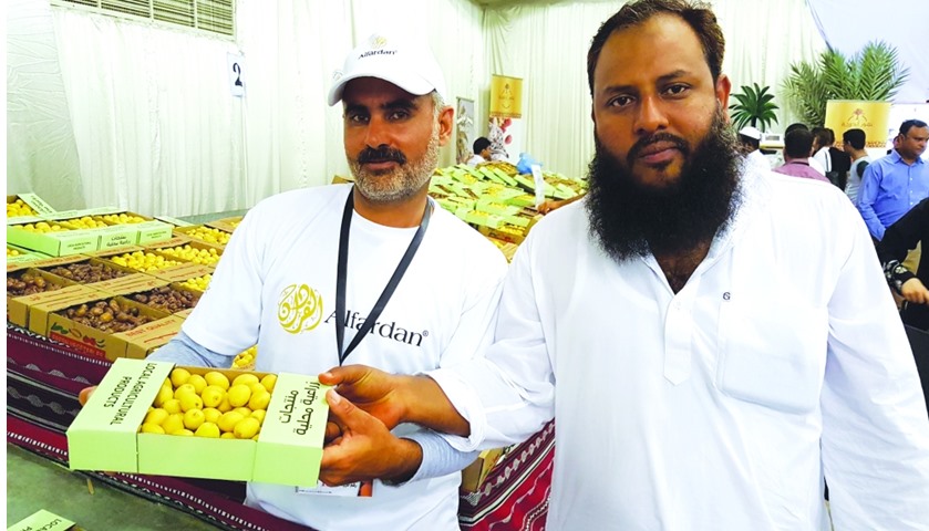 A representative of the Alfardan farm and a customer showing a box of dates at the event.

