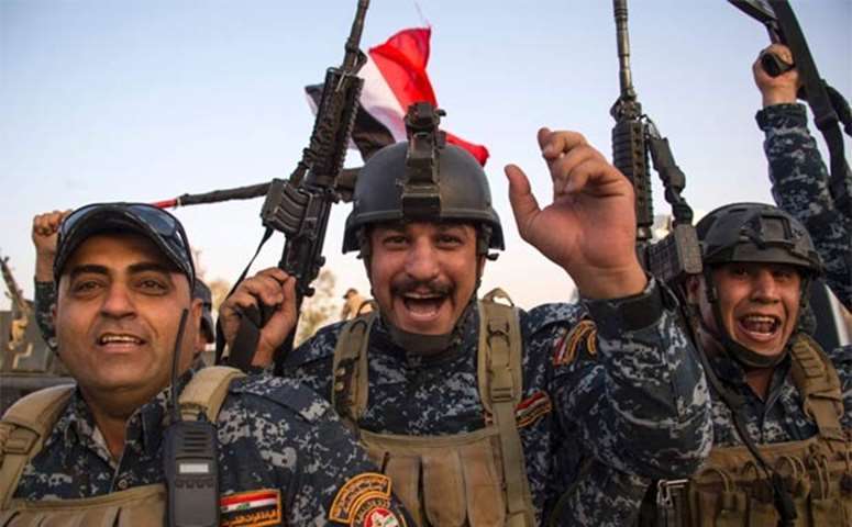 Members of the Iraqi federal police forces celebrate in the Old City of Mosul