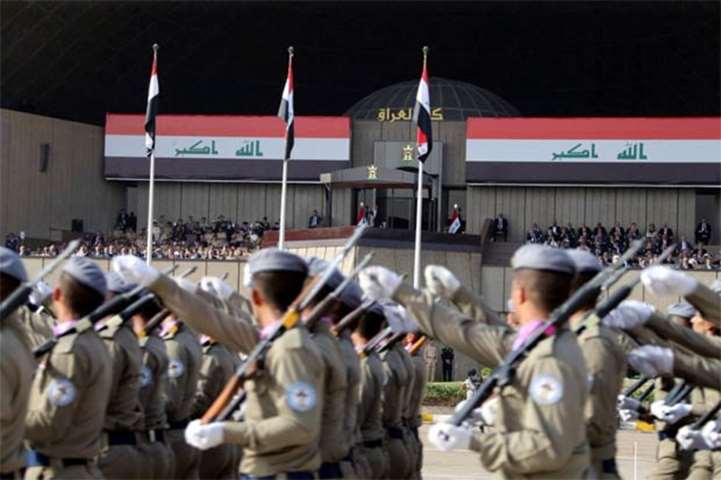 Prime Minister Haider al-Abadi waves as Iraq celebrates its victory with a military parade