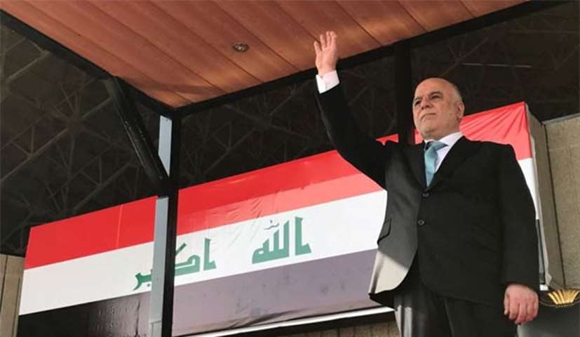 Prime Minister Haider al-Abadi raises his hand during the celebration to mark the victory in Mosul