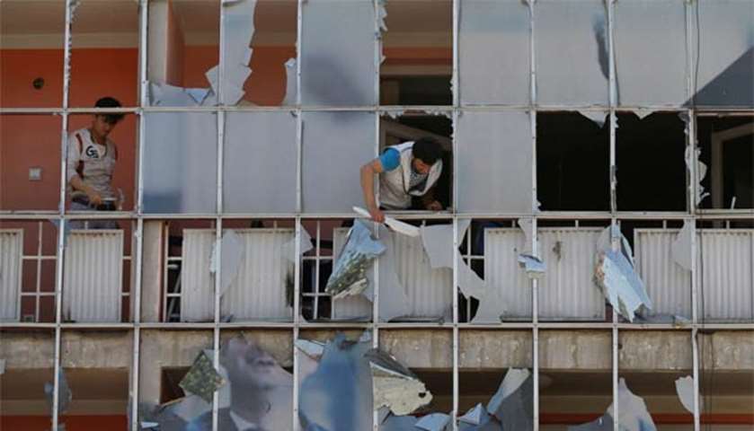 An Afghan man removes fragments of glass from a building in Kabul