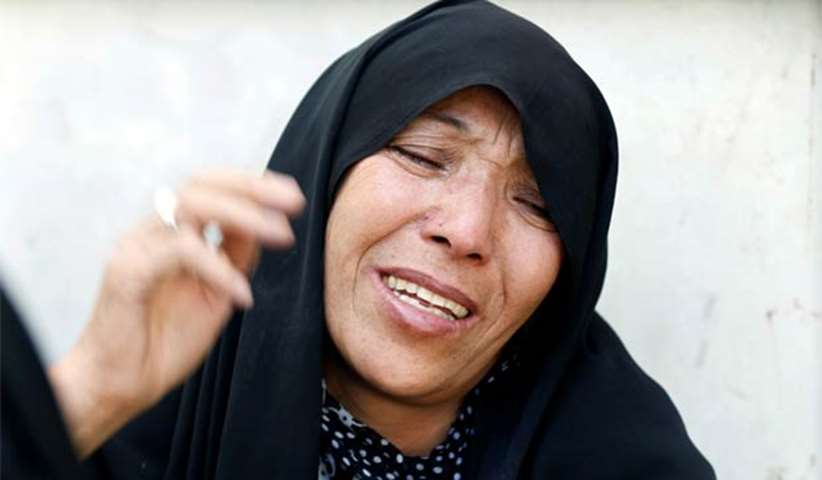 An Afghan woman mourns inside a hospital compound after a suicide attack