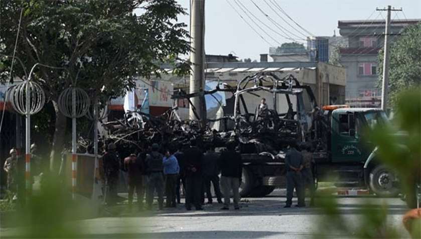 Afghan security forces remove a damaged bus after a car bomb attack on Monday