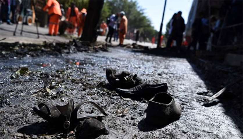 Footwear of victims are seen on the ground as Afghan residents inspect the site of a car bomb attack