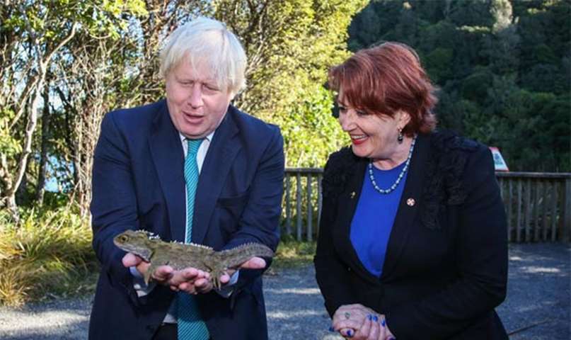 Boris Johnson holds a tuatara lizard as New Zealand\'s Conservation Minister Maggie Barry looks on