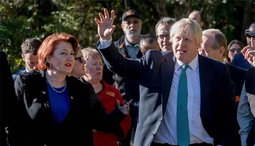 Boris Johnson gestures as he chats with New Zealand\'s Conversation Minister Maggie Barry