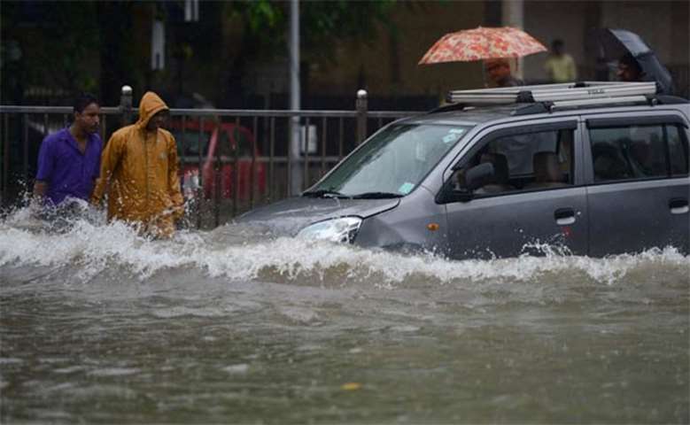 People drive along a flooded street during heavy rain in Mumbai on Tuesday