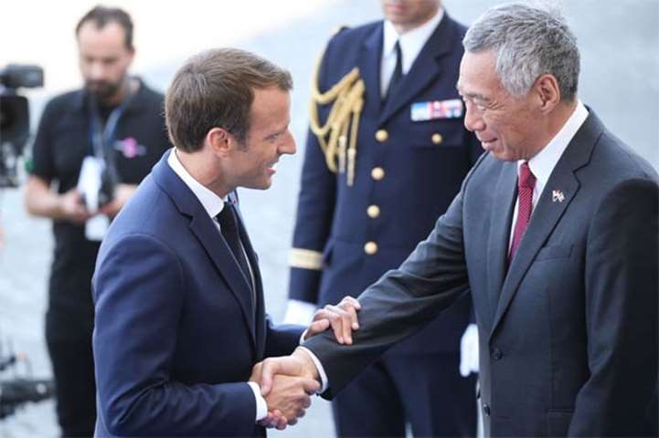 Emmanuel Macron welcomes Singapore Prime Minister Lee Hsien Loong for the Bastille Day parade