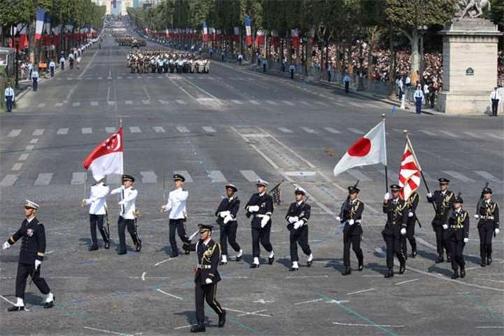 Singaporean and Japanese troops carry their national flags as they take part in the parade