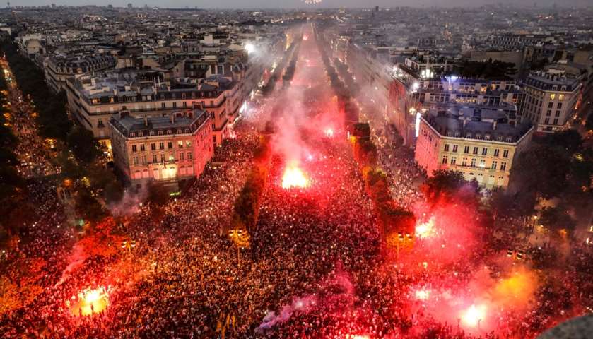 People lighting flares as they celebrate on the Champs-Elysees avenue