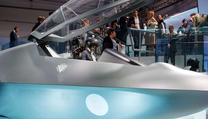 Visitors look at the model of a new fighter jet, a part of Team Tempest