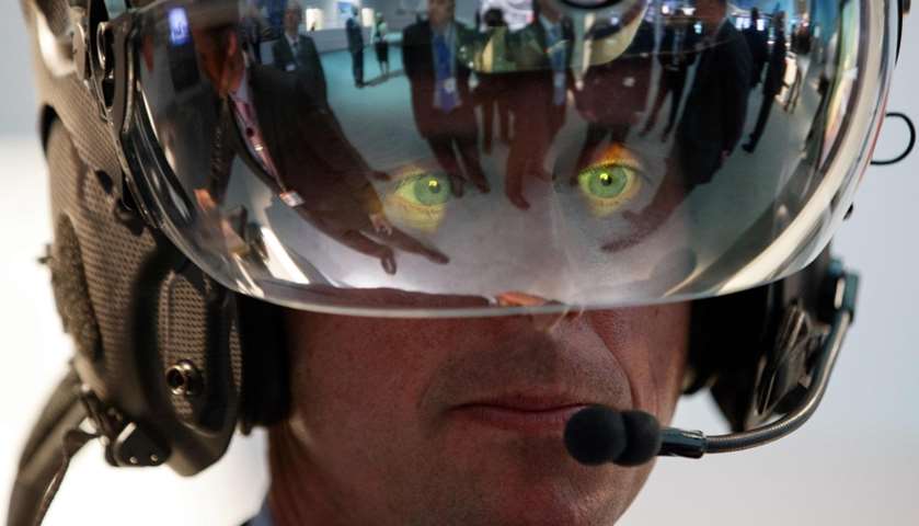 A visitor tries on a Striker II helmet mounted display at the BAE Systems showroom