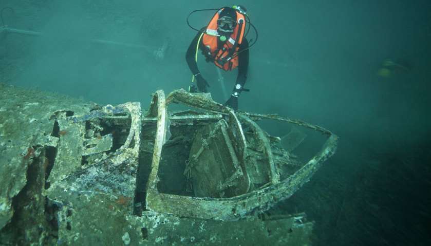 Divers explore the wreck of WWII fighter aircraft P47 Thunderbolt
