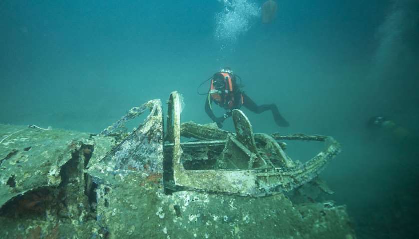 A divers explore the wreck of a P47 Thunderbolt, a US WWII fighter aircraft