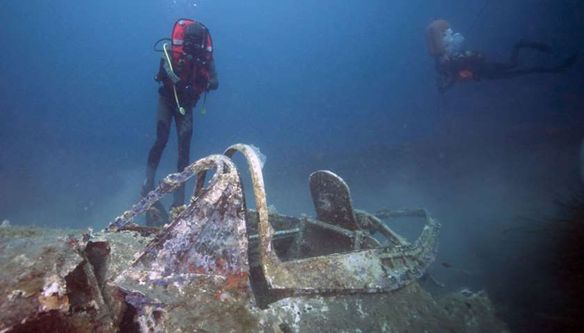 Divers explore the wreck of a P47 Thunderbolt, a US WWII fighter aircraft