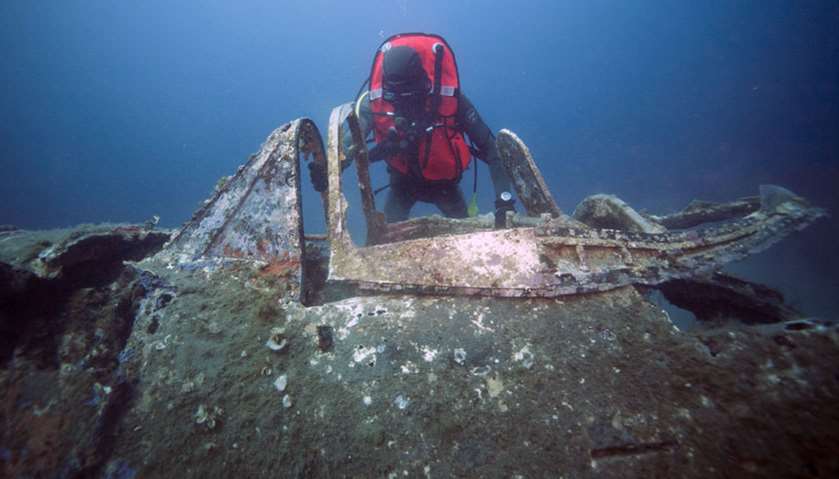 Divers explore the wreck of WWII fighter aircraft P47 Thunderbolt