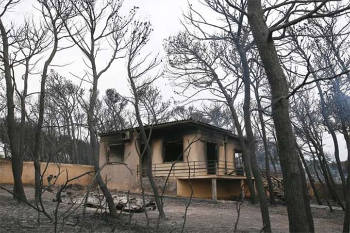 A burnt house is seen following a wildfire in Mati, near Athens, on Tuesday