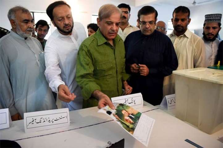 Shahbaz Sharif, head of Pakistan Muslim League-Nawaz, shows his ballot papers in Lahore