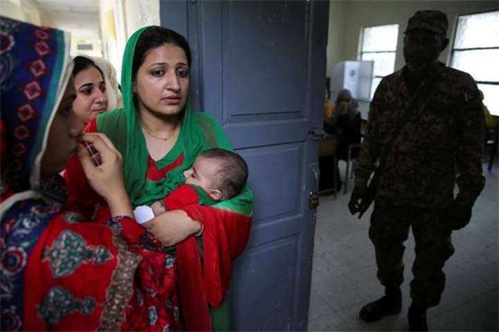 Voters wait to enter a polling station in Islamabad on Wednesday