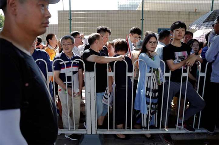 People wait in a queue outside the US embassy in Beijing on Thursday