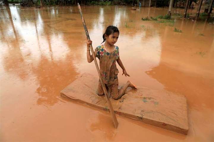 A girl uses a mattress as a raft during the flood after the Xepian-Xe Nam Noy dam collapsed