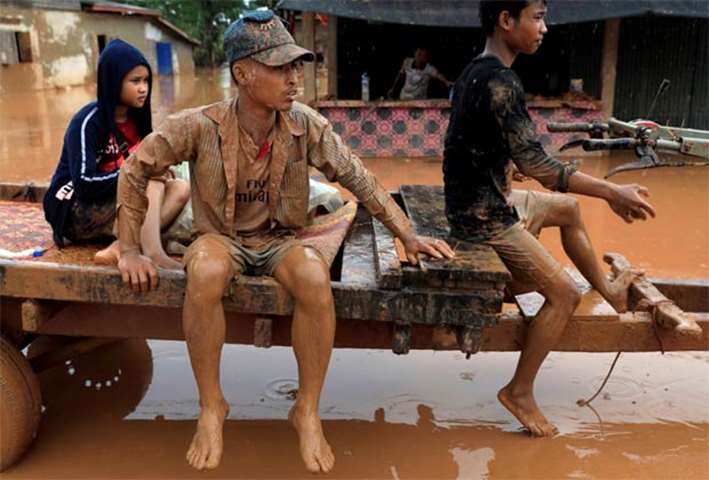 People ride a vehicle on a street after the Xepian-Xe Nam Noy dam collapsed in Attapeu province