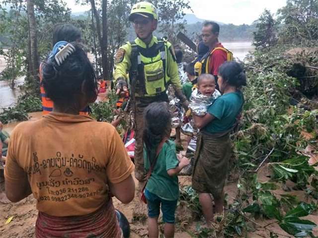 A Thai team rescuing flood survivors, including a baby trapped in a village, in Attapeu province