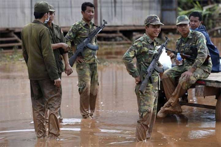Laos soldiers secure a flooded village in Sanamxai, Attapeu province, as rescuers battled fresh rain