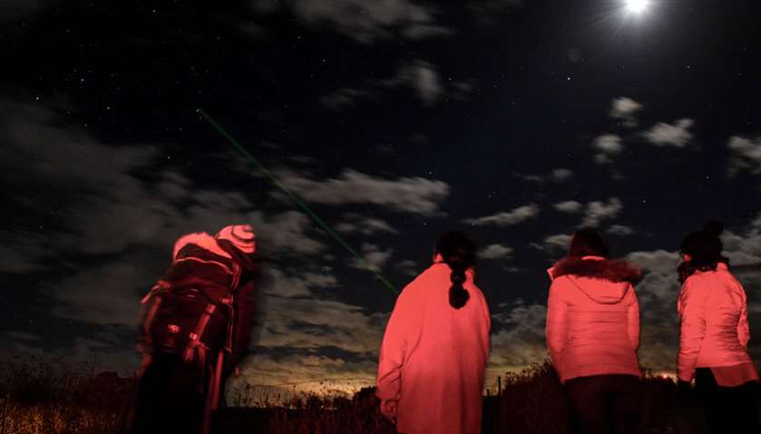 Tourists observe the night sky in Chiu Chiu, some 75 km from Calama, Chile