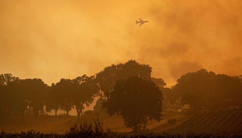 An air tanker flies over a vineyard during the Mendocino Complex fire in Lakeport, California