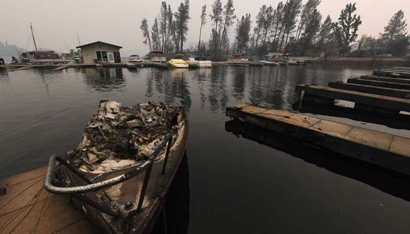 A burnt out boat sits at a marina on Whiskeytown Lake after damage from the Carr fire near Redding
