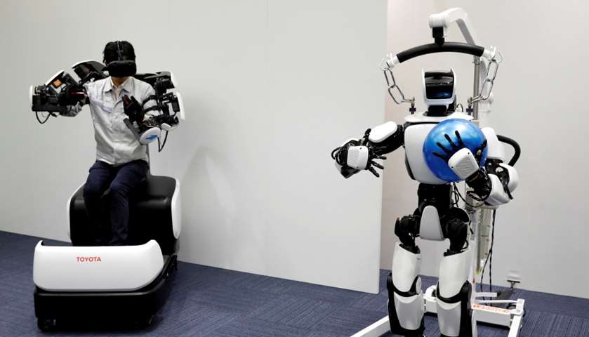An employee of Toyota Motor Corp. demonstrates a T-HR3 humanoid robot