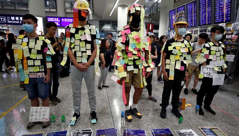 Demonstrators wear post-it notes as part of the \"Lennon Wall\" movement during a protest against the 